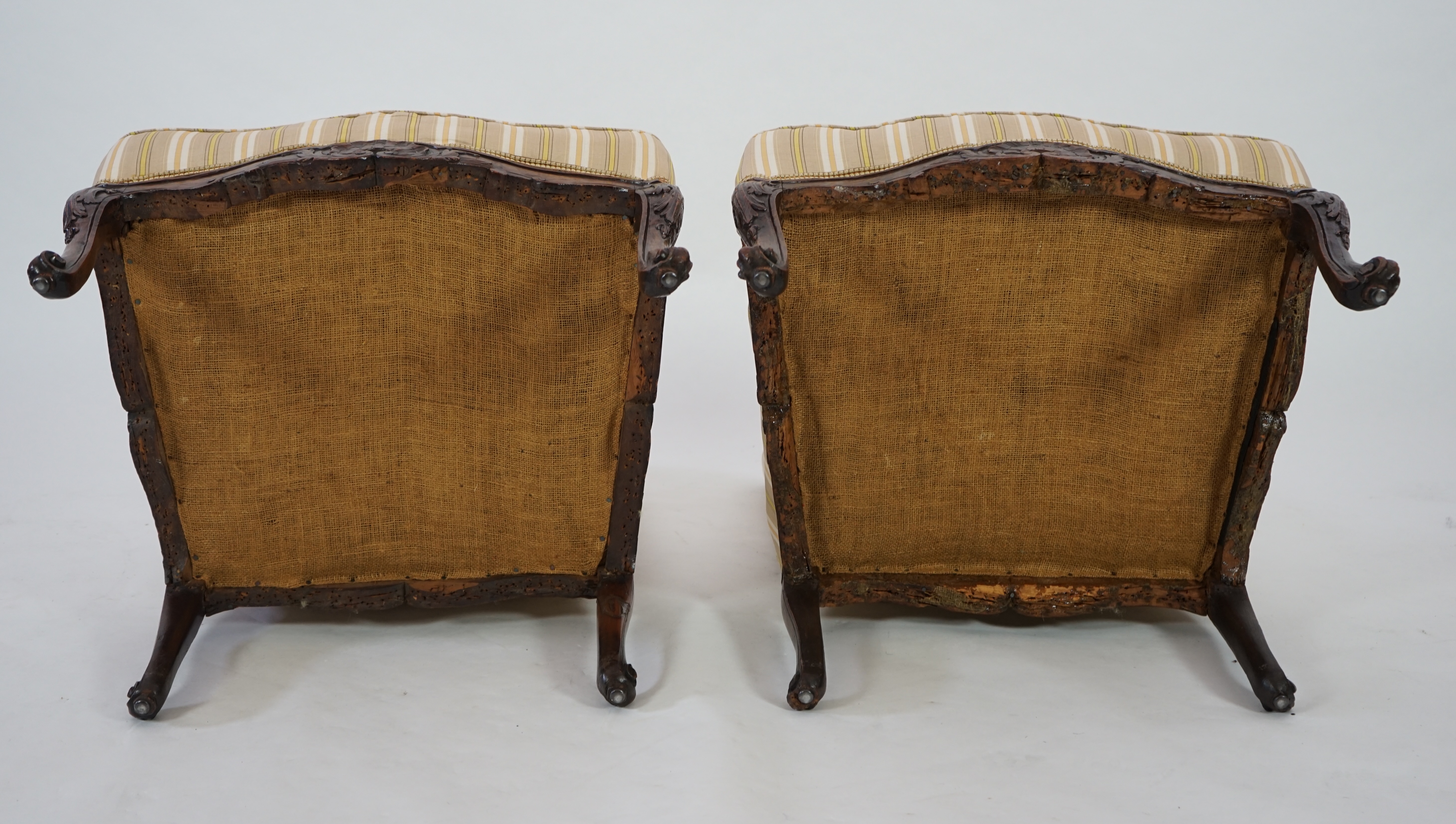 A pair of Louis XVI walnut fauteuils with upholstered backs and seats and foliate carved arms and underframes, on cabriole legs, width 67cm, depth 76cm, height 104cm. Condition - fair